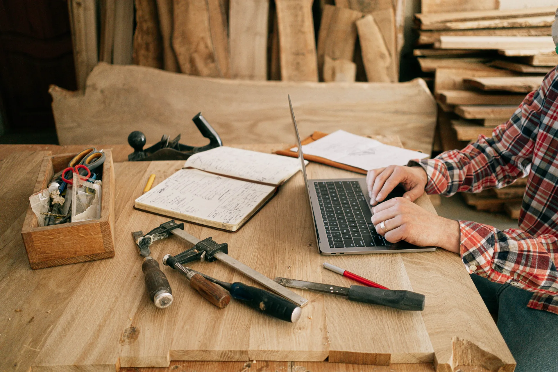Business owner at a laptop surrounded by tools