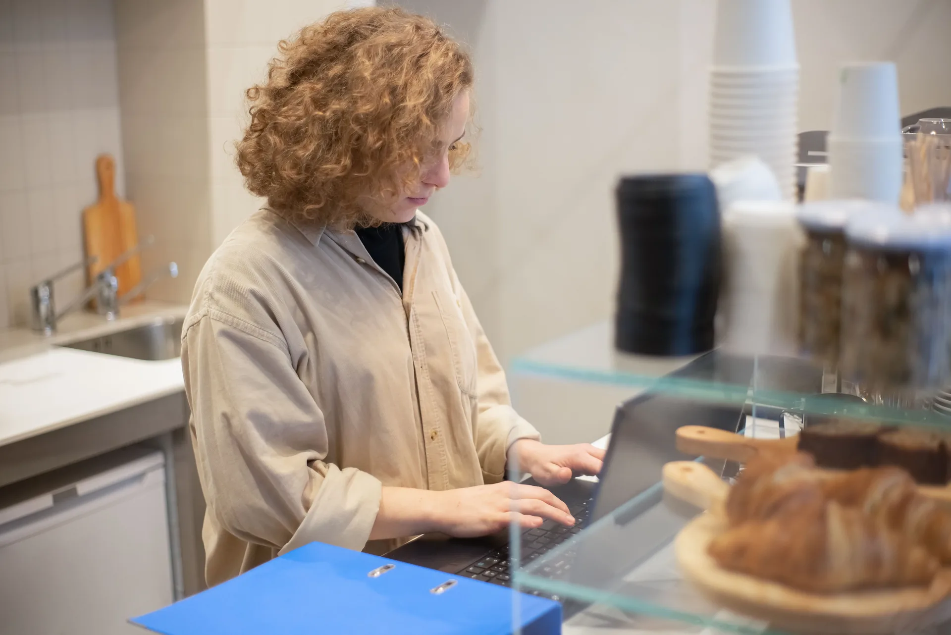 Business owner working on a laptop behind the counter
