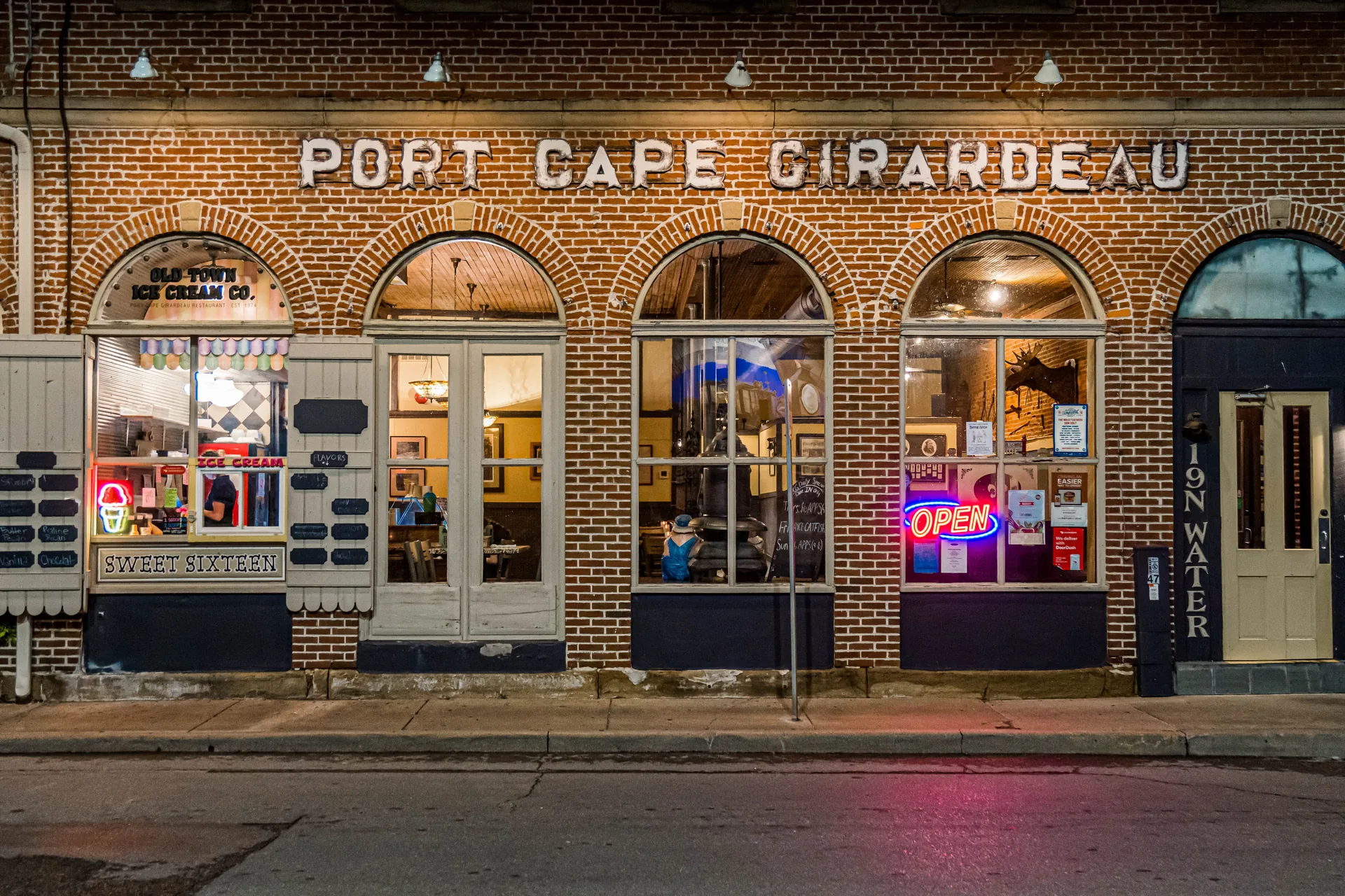 Ice cream shop storefront with the OPEN sign lit