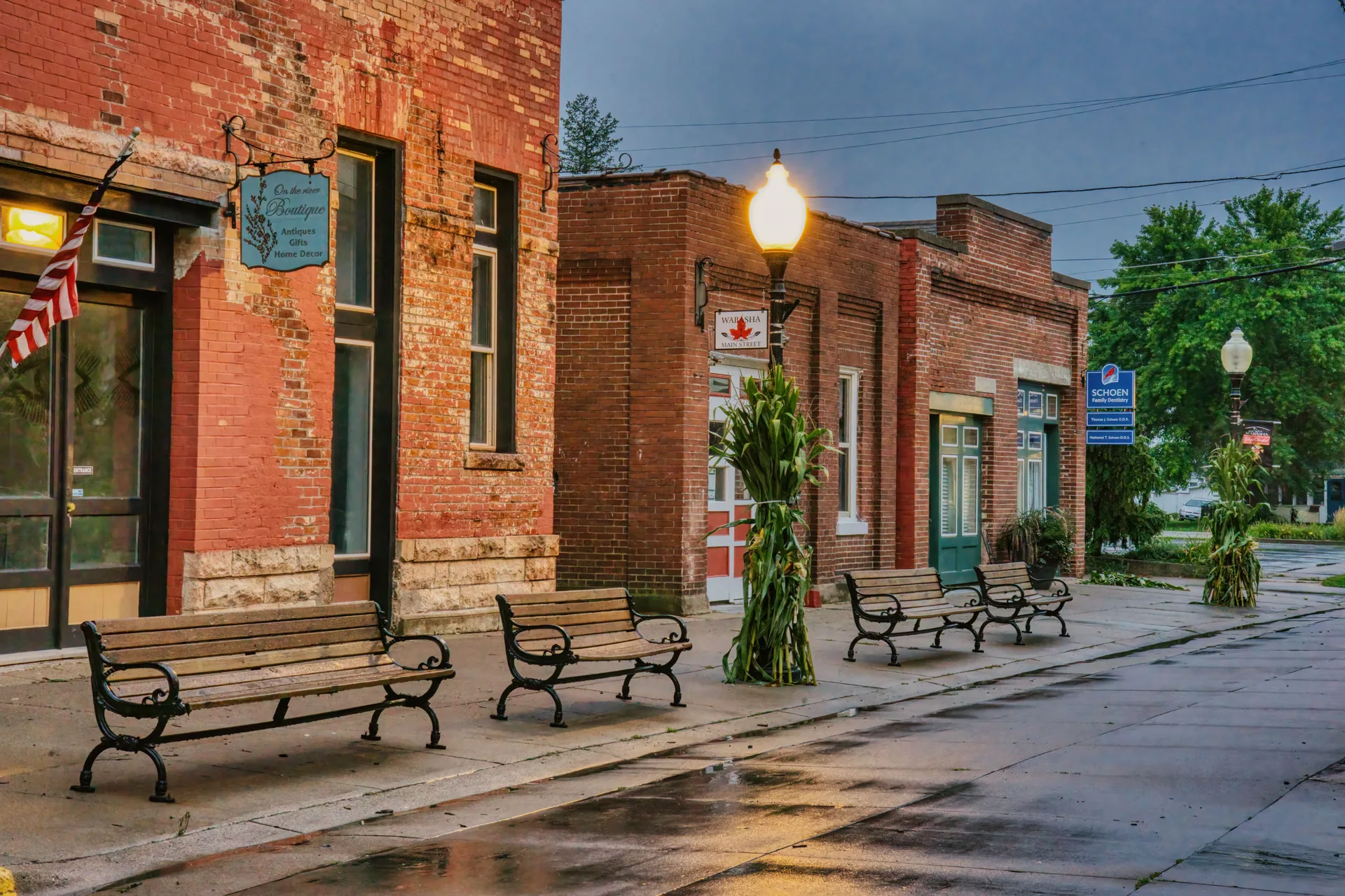 Benches outside brick storefronts on a small-town street