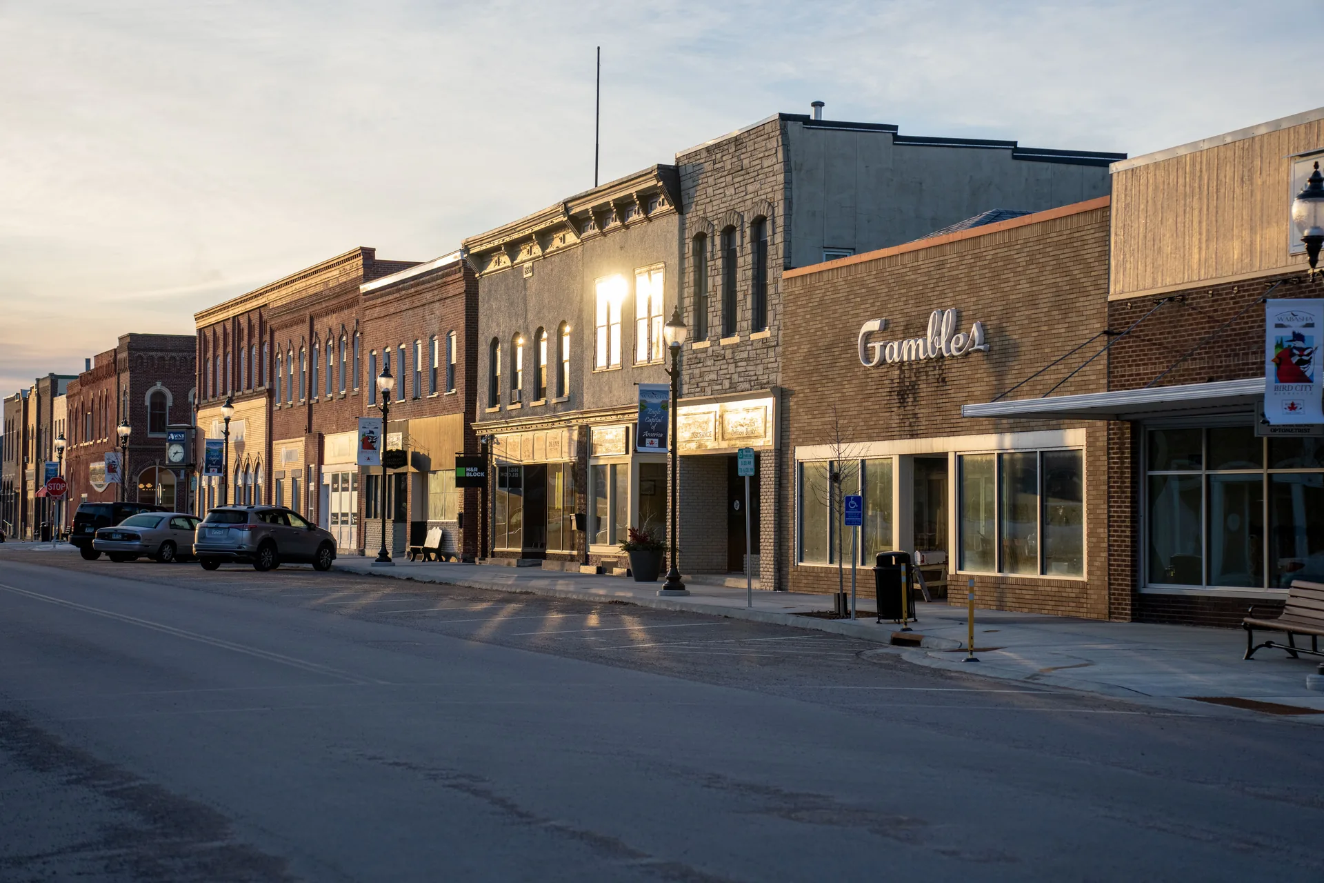 Brick storefronts on a small-town Main Street at sunset
