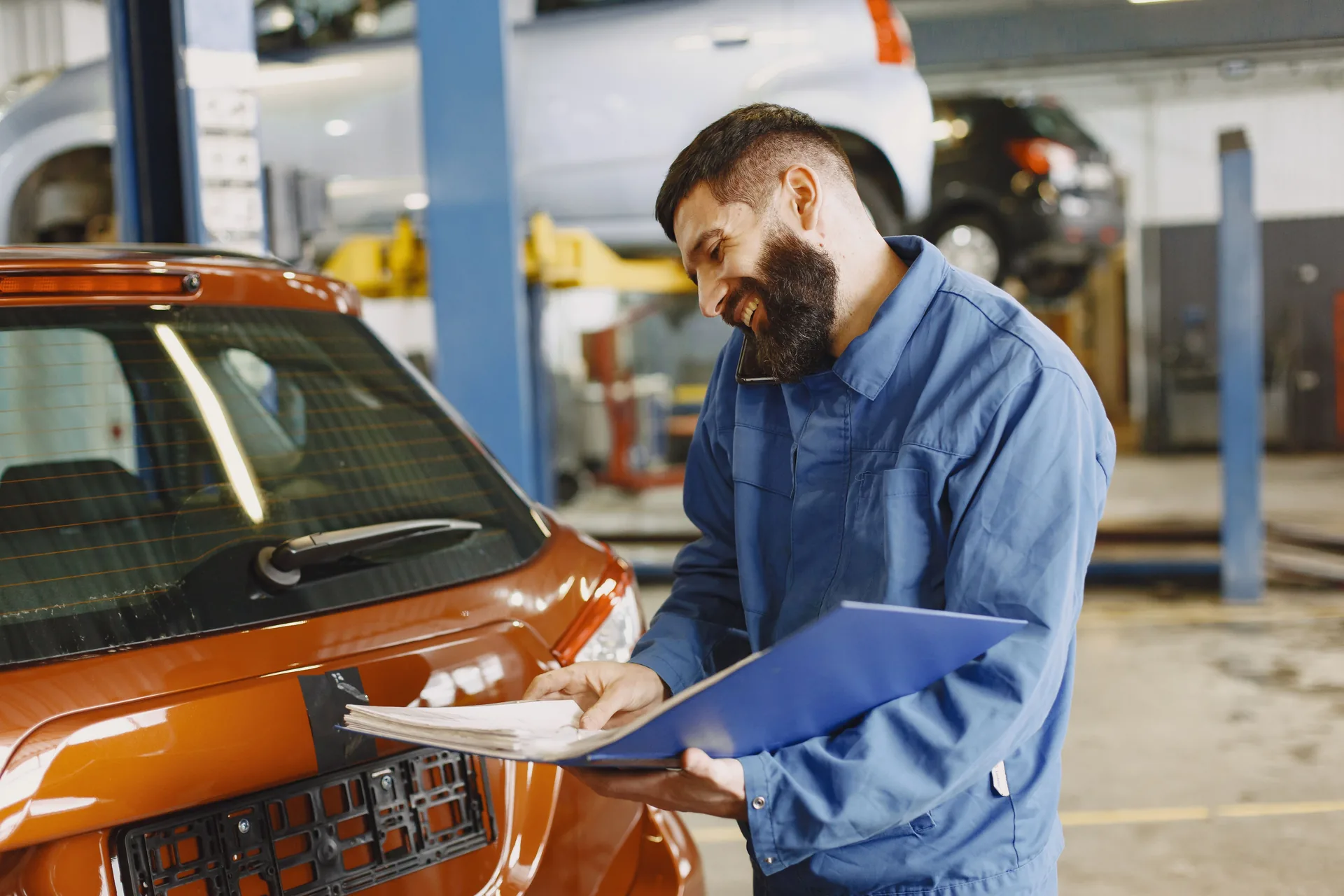 Auto mechanic with a clipboard in the service bay